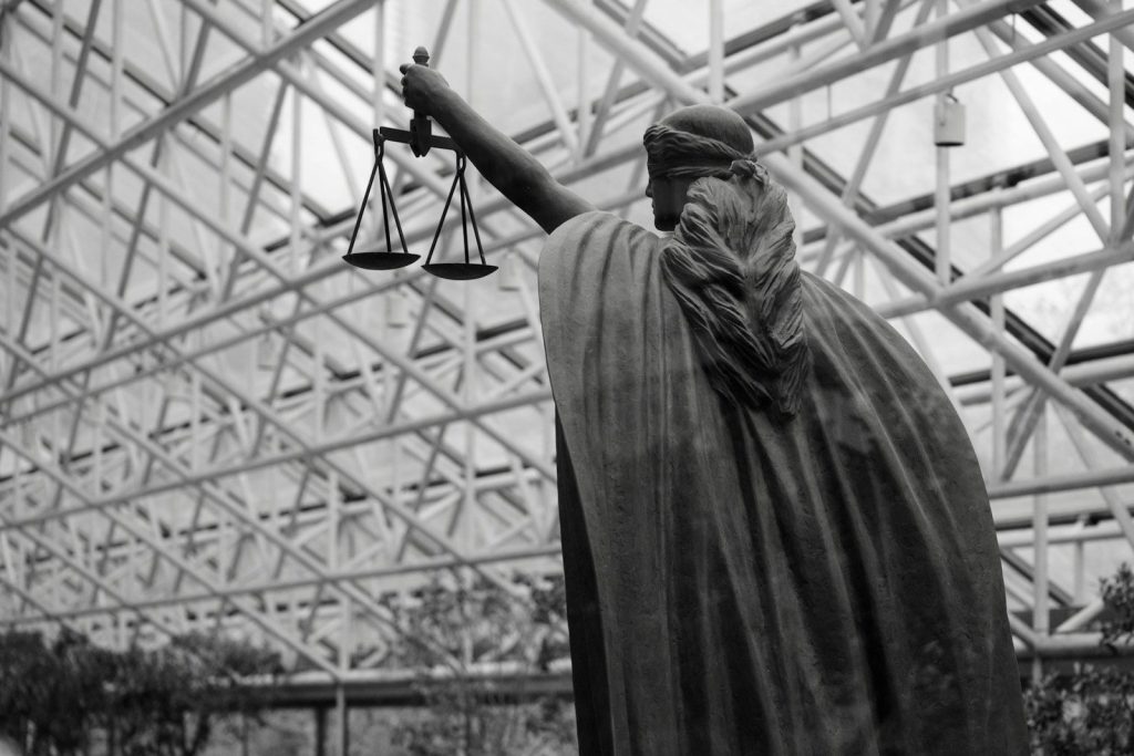 Statue of lady justice holding scales indoors