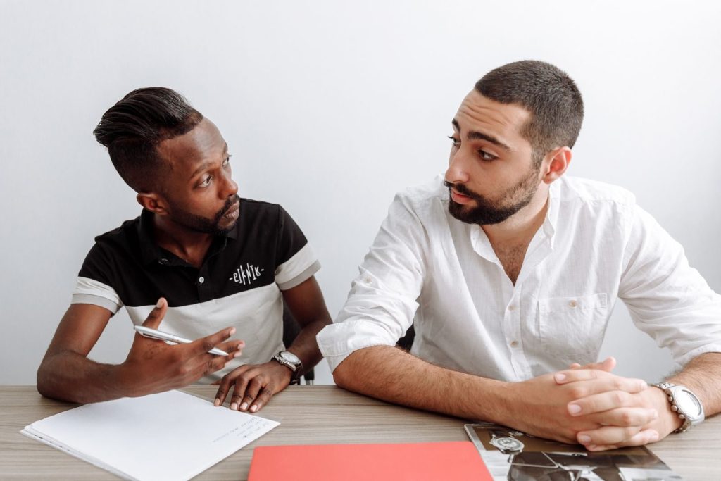 Two diverse men engage in a serious office discussion, emphasizing collaboration and teamwork.